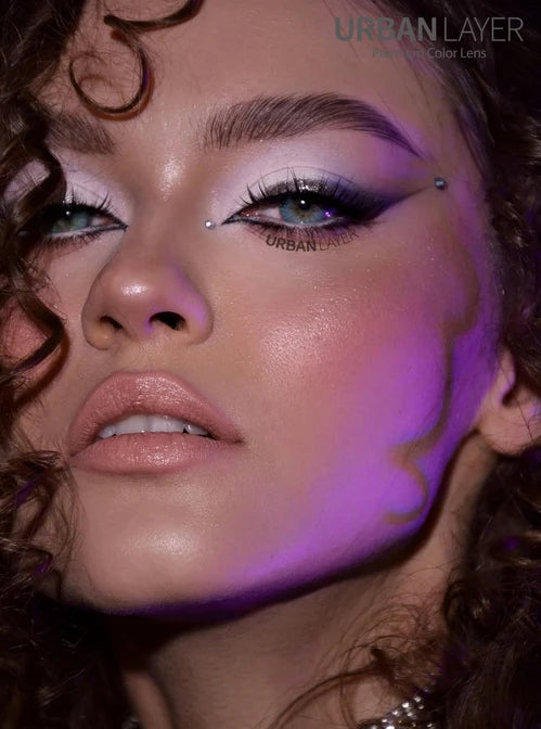 Close-up of a person with makeup and 'Urban Layer' branding.