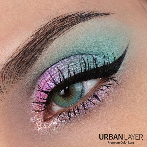 Close-up of an eye with colorful makeup and 'Urban Layer' branding.